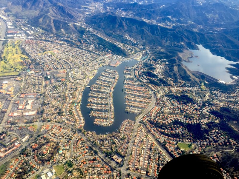 Aerial view of Westlake Lake and surrounding Westlake Village neighborhoods with Santa Monica Mountains beyond
