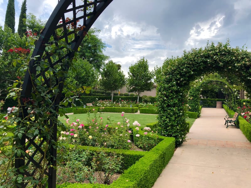 Rose garden with trellised arches and manicured hedges at Gardens of the World in Thousand Oaks