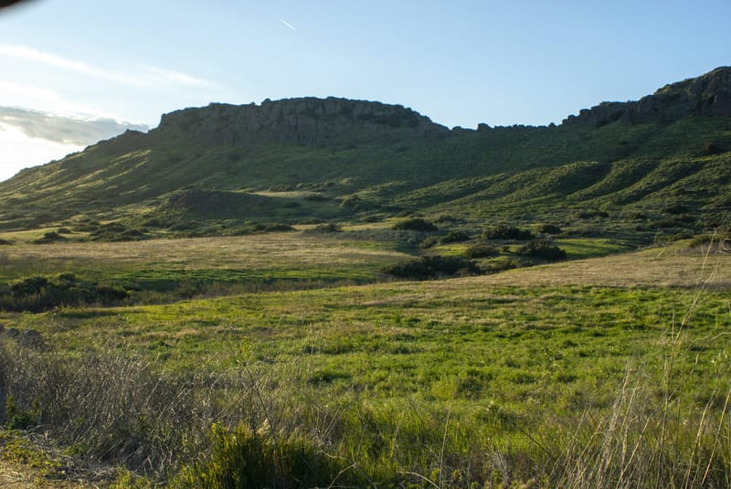 Green rolling meadow and volcanic rock ridge at Wildwood Park in Thousand Oaks